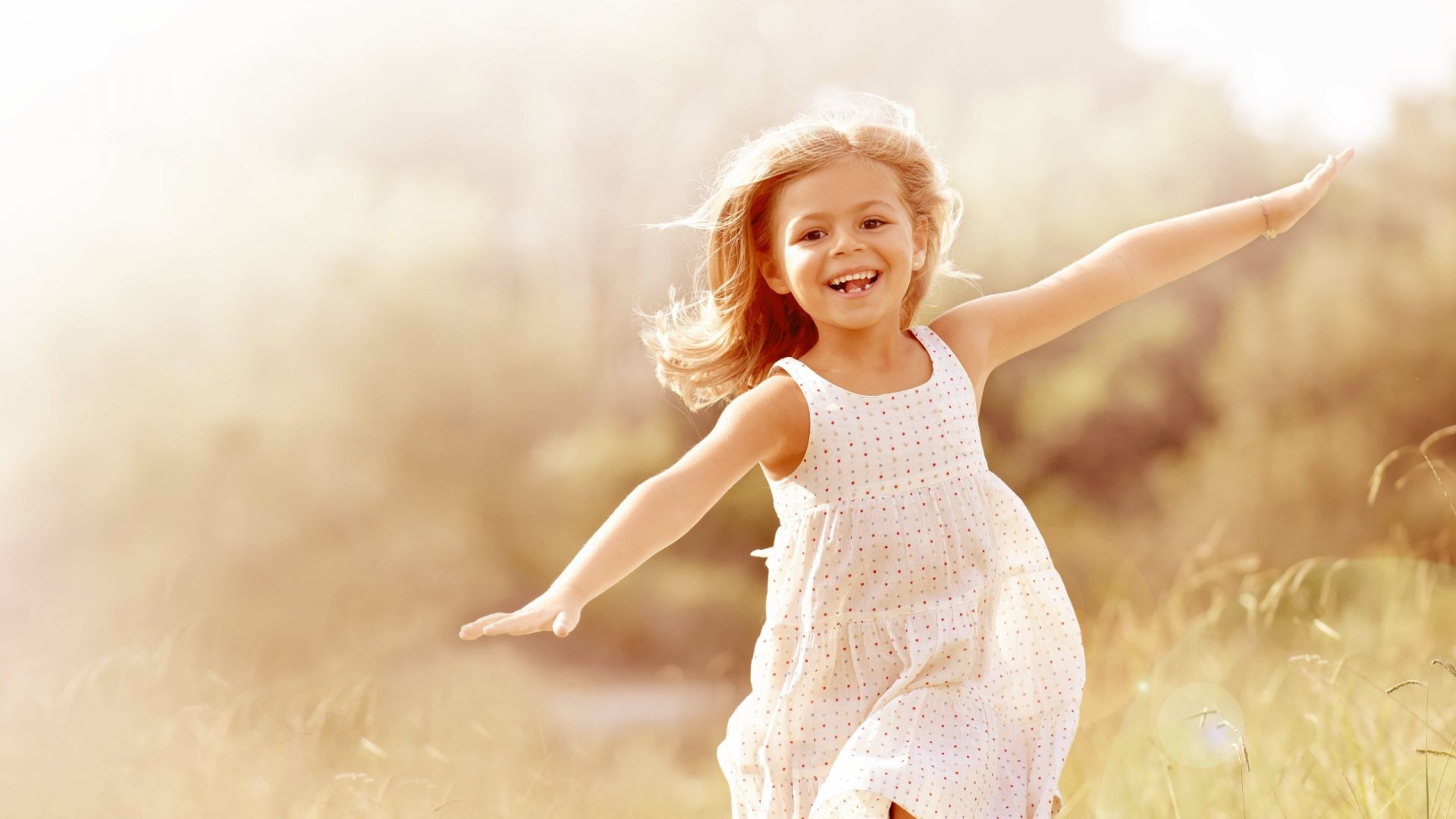 Little girl running in country field in summer