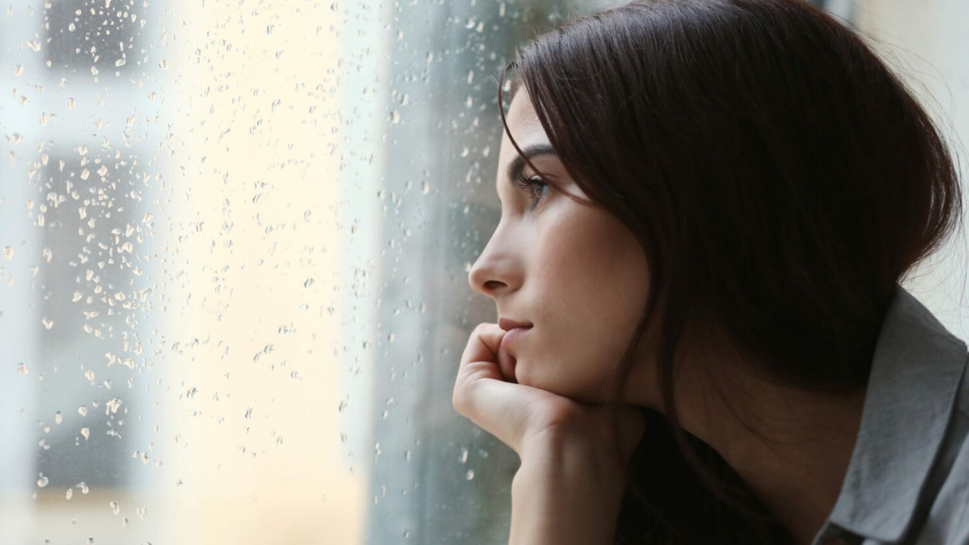 Depressed young woman near window at home, closeup Depressed young woman near window at home, closeup